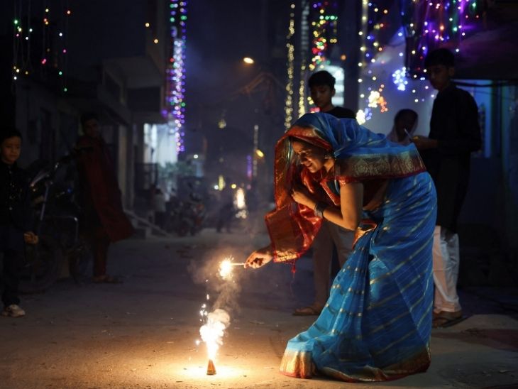 दिल्ली की गीता कॉलोनी में पटाखे जलाती महिला।