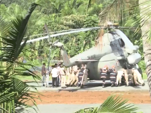 द्रौपदी मुर्मू के हेलिकॉप्टर को गड्ढे से निकालते पुलिस और अग्निशमन कर्मी।