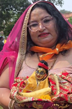 मथुरा में गोवर्धन पूजा पर महिला लड्‌डू गोपाल को गोद में लेकर पहुंची हैं।