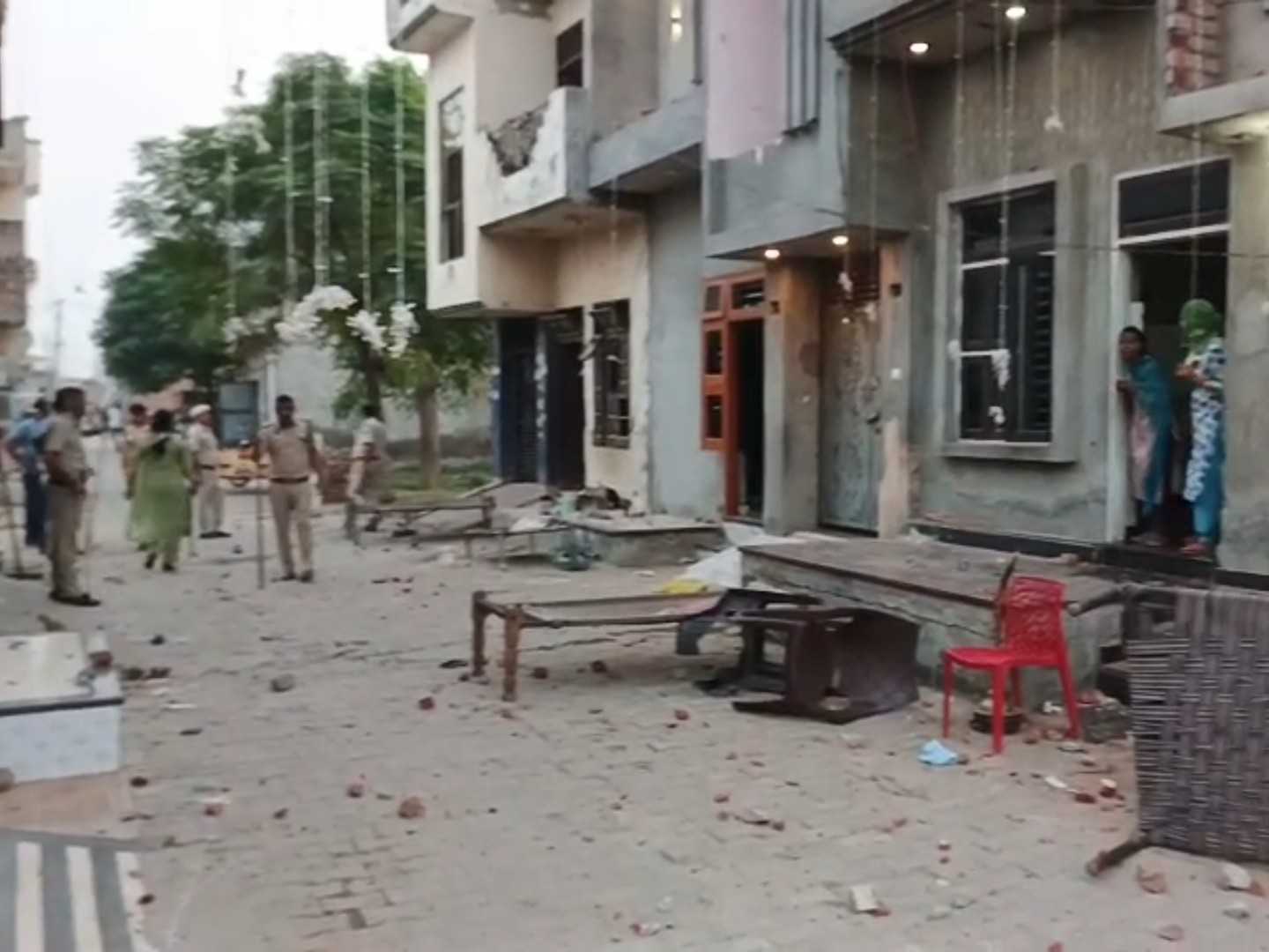 गली में बिखरे ईंट-पत्थर।