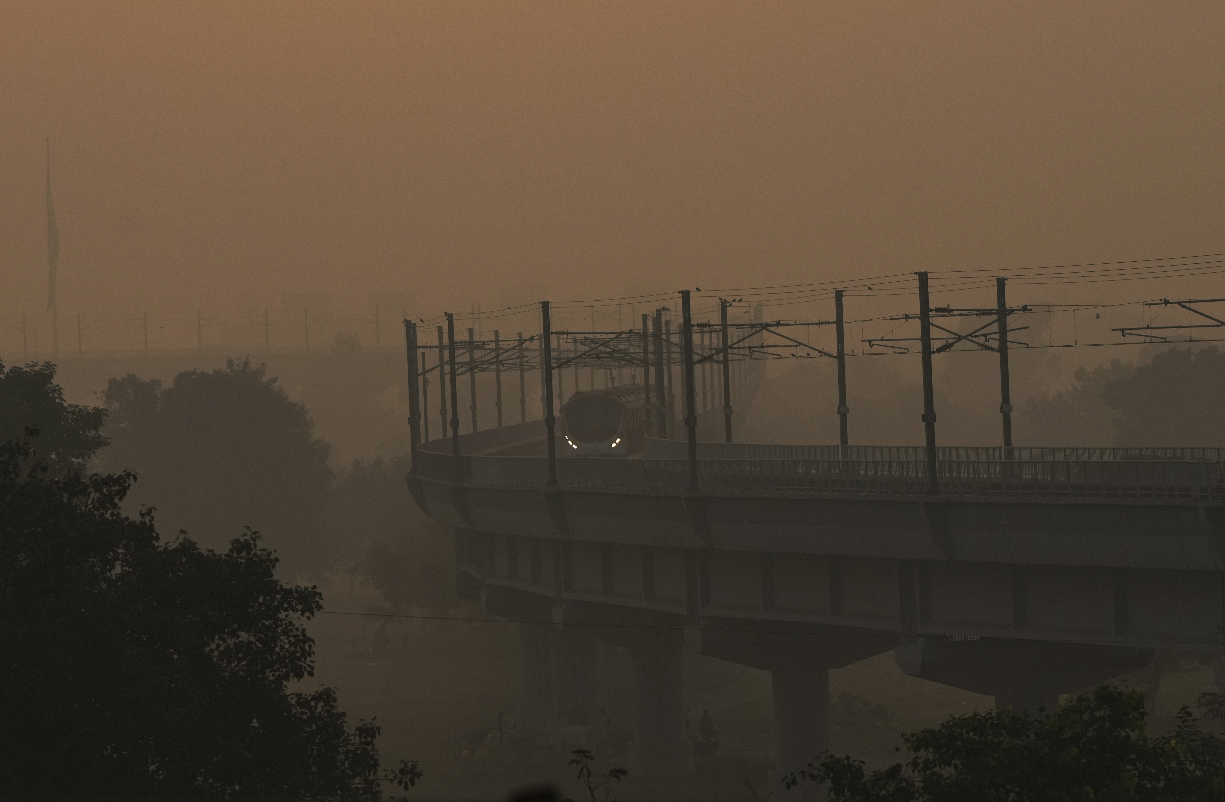 नई दिल्ली में विजिबिलिटी कम हो गई। धुंध के बीच से गुजरती मेट्रो।