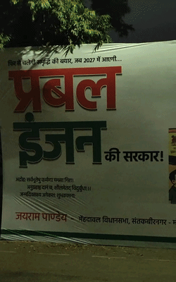 होर्डिंग में लोकसभा चुनाव-2024 और विधानसभा चुनाव-2007 को स्टेशनों के रूप में दिखाया गया है।