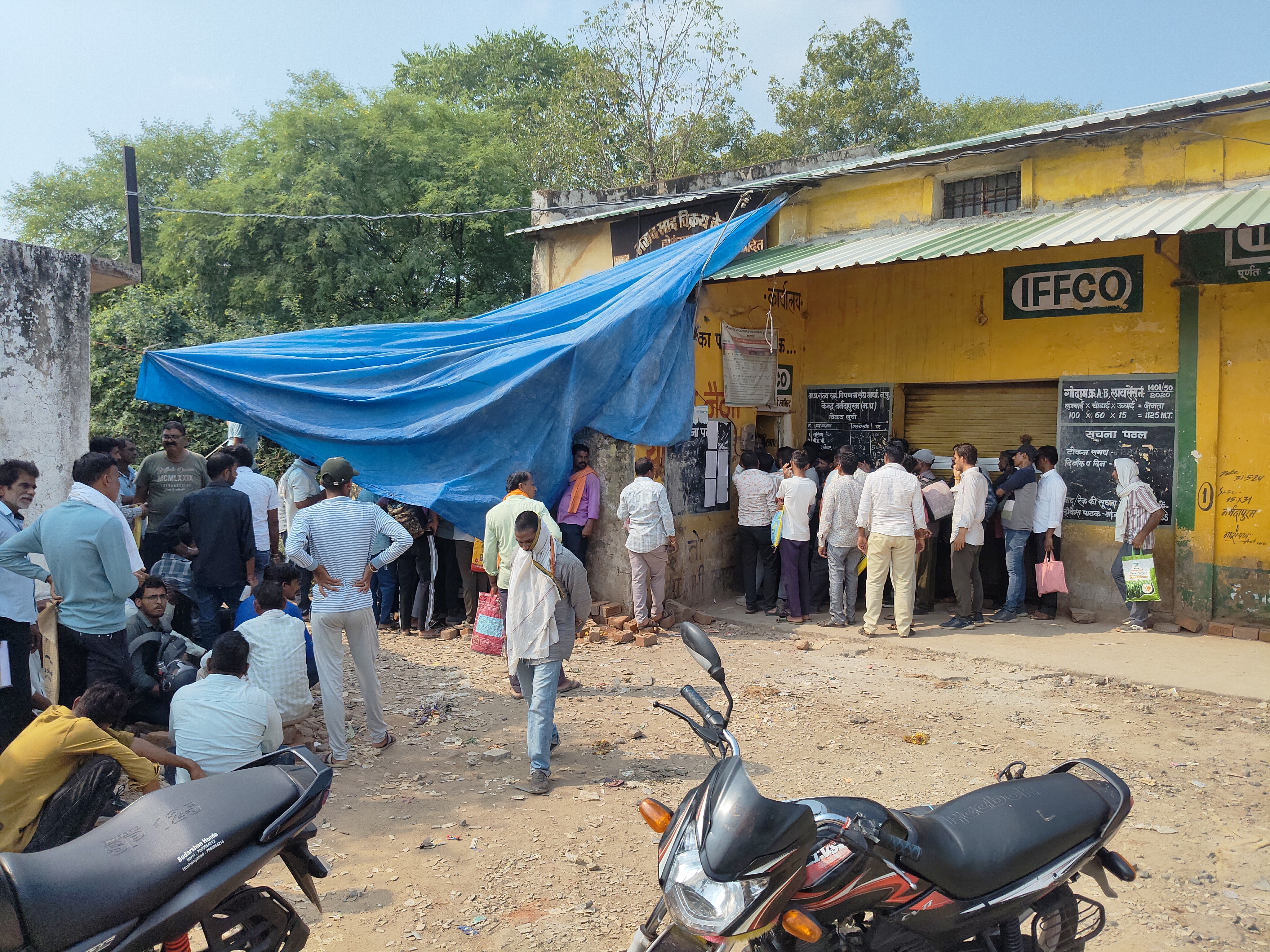 डबल लॉक गोदाम पर धूप में खड़े किसानों की भीड़।