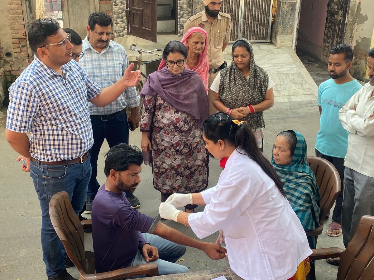 कैंप लगाकर लोगों की जांच करते डॉक्टर।