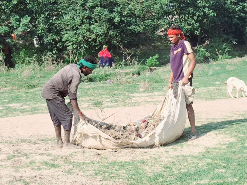 घाट पर सफाई करते सफाई कर्मी।