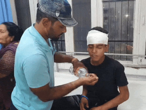 हादसे में घायल हुए बच्चे को पानी पिलाता उनका रिश्तेदार।