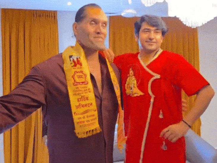 द ग्रेट खली के बराबर में खड़े होकर फोटो लेते धीरेंद्र शास्त्री।