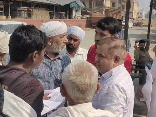 करनाल की मंडी में फर्जी गेटपास को लेकर बात करते किसान।