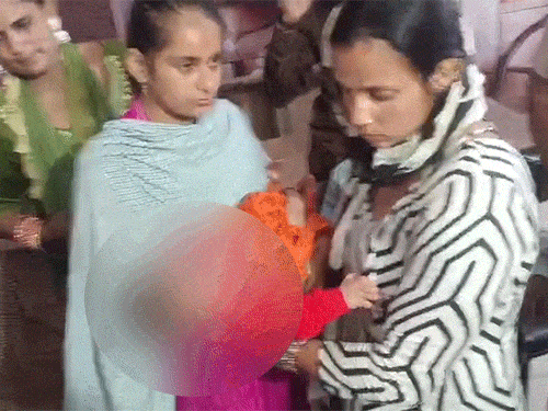 बच्चे को देती हुई गुरमन कौर (पिंक सूट में)। उसने नशा तस्करों को ही बच्चा बेच दिया। रविवार शाम पुलिस ने बच्चा बेचने वाले माता-पिता और खरीदने वाले आरोपी को गिरफ्तार कर लिया। - Dainik Bhaskar