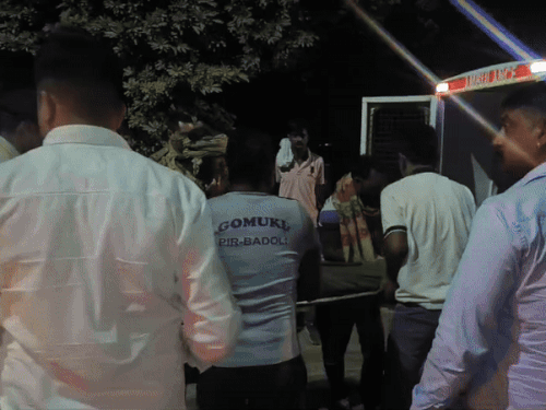 शव को शव वाहन में रखवाती पुलिस।