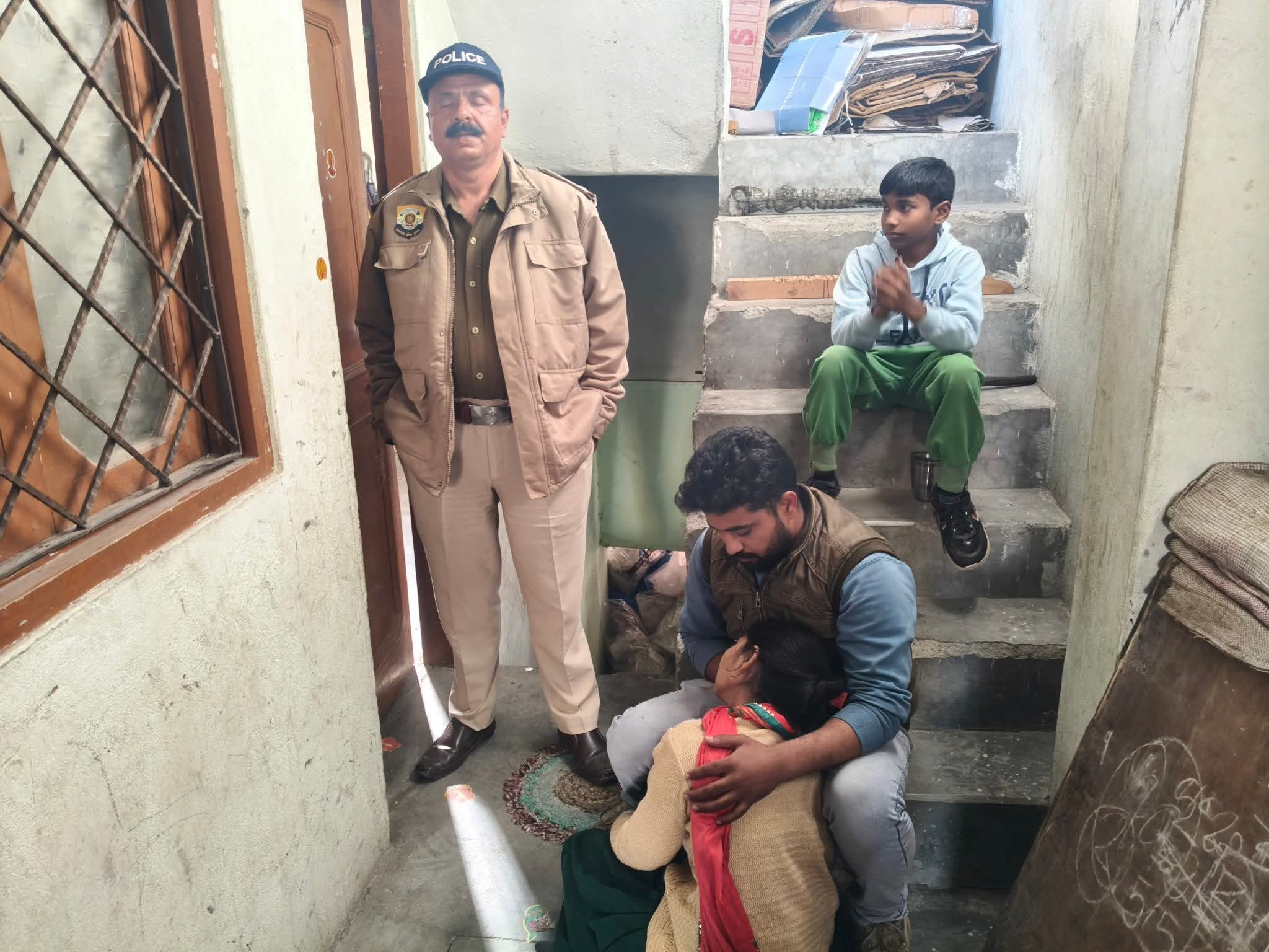 मंडी के पंडोह में कमरे के बाहर खड़ा पुलिस जवान और विलाप करते हुए परिजन।