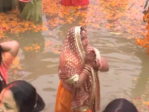 यूपी के मुरादाबाद में छठ महापर्व के आखिरी दिन सूर्य को अर्घ्य देतीं महिलाएं।