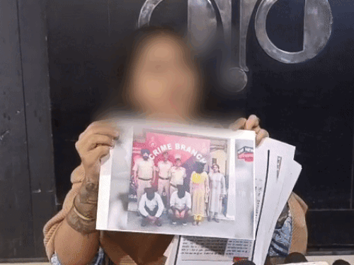 प्रेस कॉन्फ्रेंस के दौरान ससुराल वालों की गिरफ्तारी के फोटो दिखाती मॉडल
