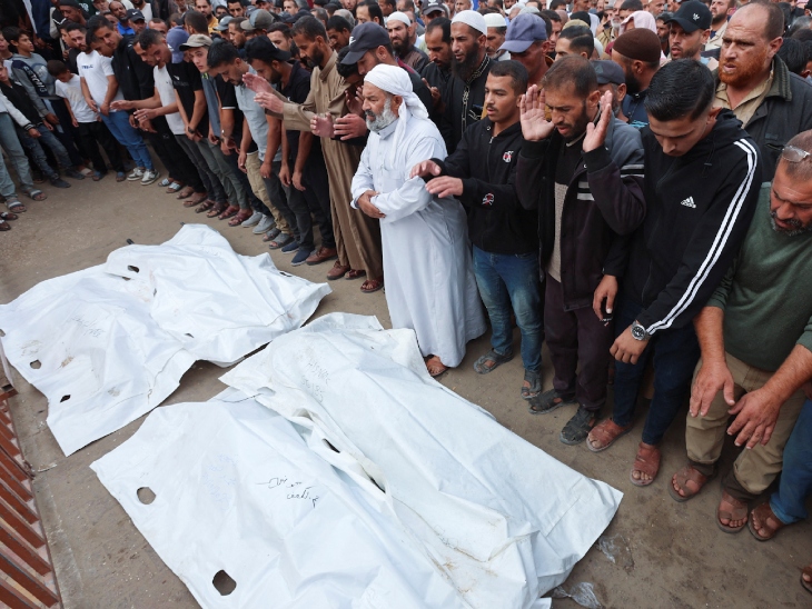 गाजा पर इजराइली हमले में मारे गए लोगों का अंतिम संस्कार करते परिजन।