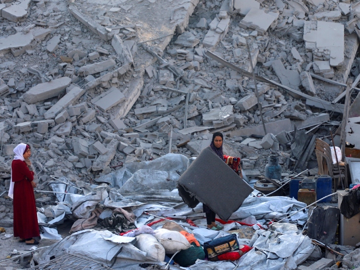 इजराइली हमले के बाद घर का बचा हुआ सामान समेटती फिलिस्तीनी महिलाएं।