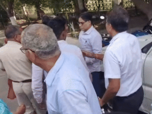 Policemen taking the supervisor during the commotion at MDU.