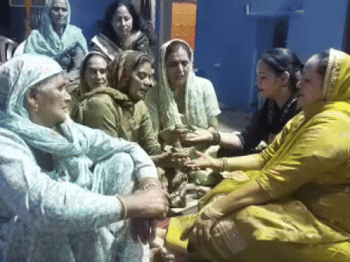 अमित पंघाल के घर मेहंदी लगवाते हुए महिलाएं।
