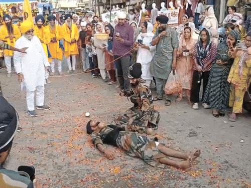 भिवानी में गुरु नानक देव के प्रकाश पर्व पर शोभा यात्रा में गर्दन पर नारियल रखकर तलवार से फोड़ते हुए