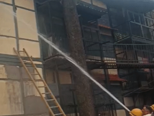 कसुम्पटी में आग बुझाते हुए दमकल कर्मी।