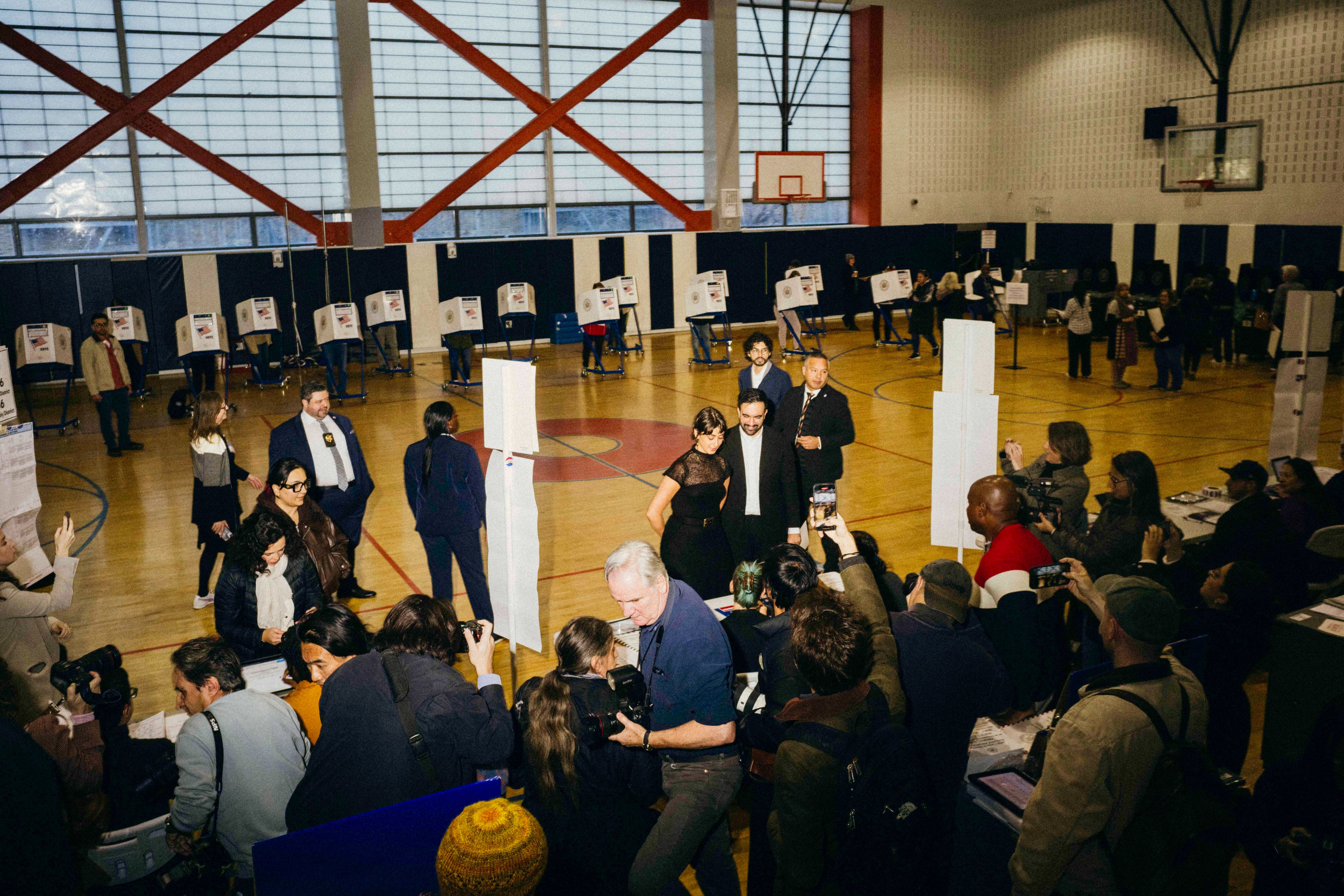 वोट देने के बाद पत्नी के साथ तस्वीर खिंचाते ममदानी।