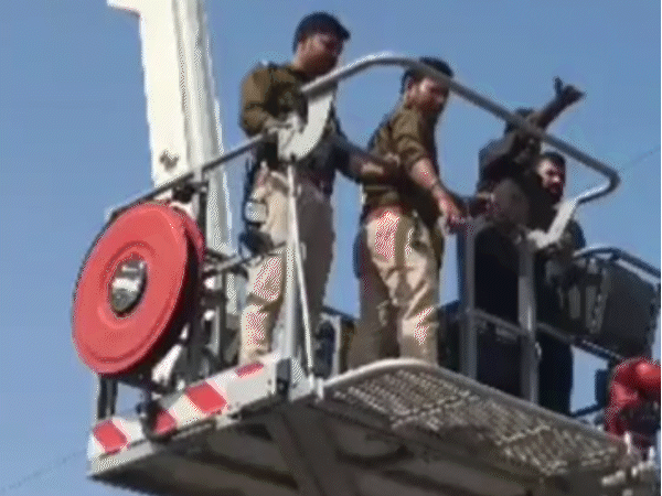 हाइड्रोलिक फायर बिग्रेड की मदद से युवक को नीचे उतारकर लाते पुलिसकर्मी।