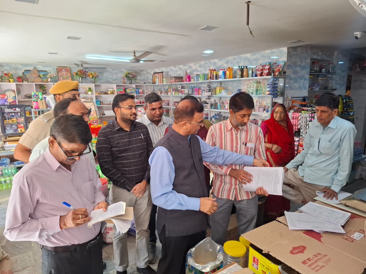 एक‌ दुकानदार को S.I.R. के बारे में जानकरी देते जिला कलेक्टर मुकुल शर्मा।