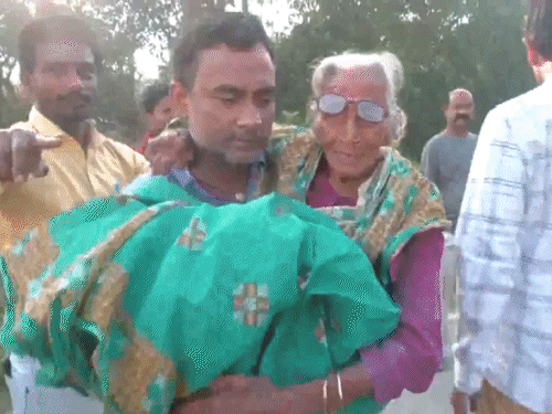 वैशाली में मां को गोद में लेकर मतदान के लिए पहुंचा बेटा।