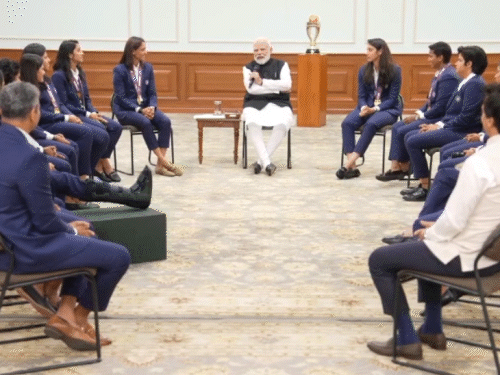 PM मोदी भारतीय महिला क्रिकेटर से बात करते हुए।