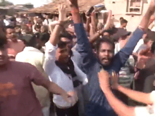 डिप्टी CM की गाड़ी के सामने प्रदर्शन करते लोग।