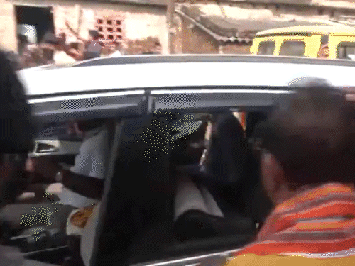 हमले के बाद सुरक्षाकर्मी विजय सिन्हा को गाड़ी में बैठाते हुए।