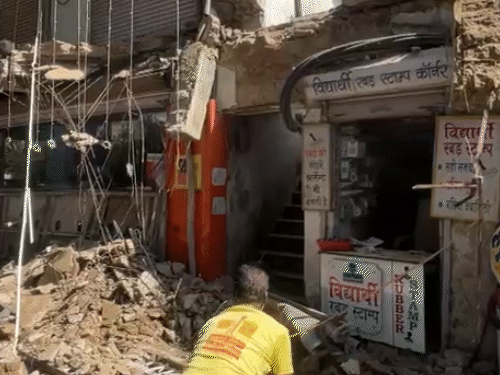 कचहरी रोड़ पर तीन दुकानों का छज्जा एक साथ धड़ाम से नीचे आ गिरा, जिससे पास में खड़ी स्कूटी भी मलबे में दब गई