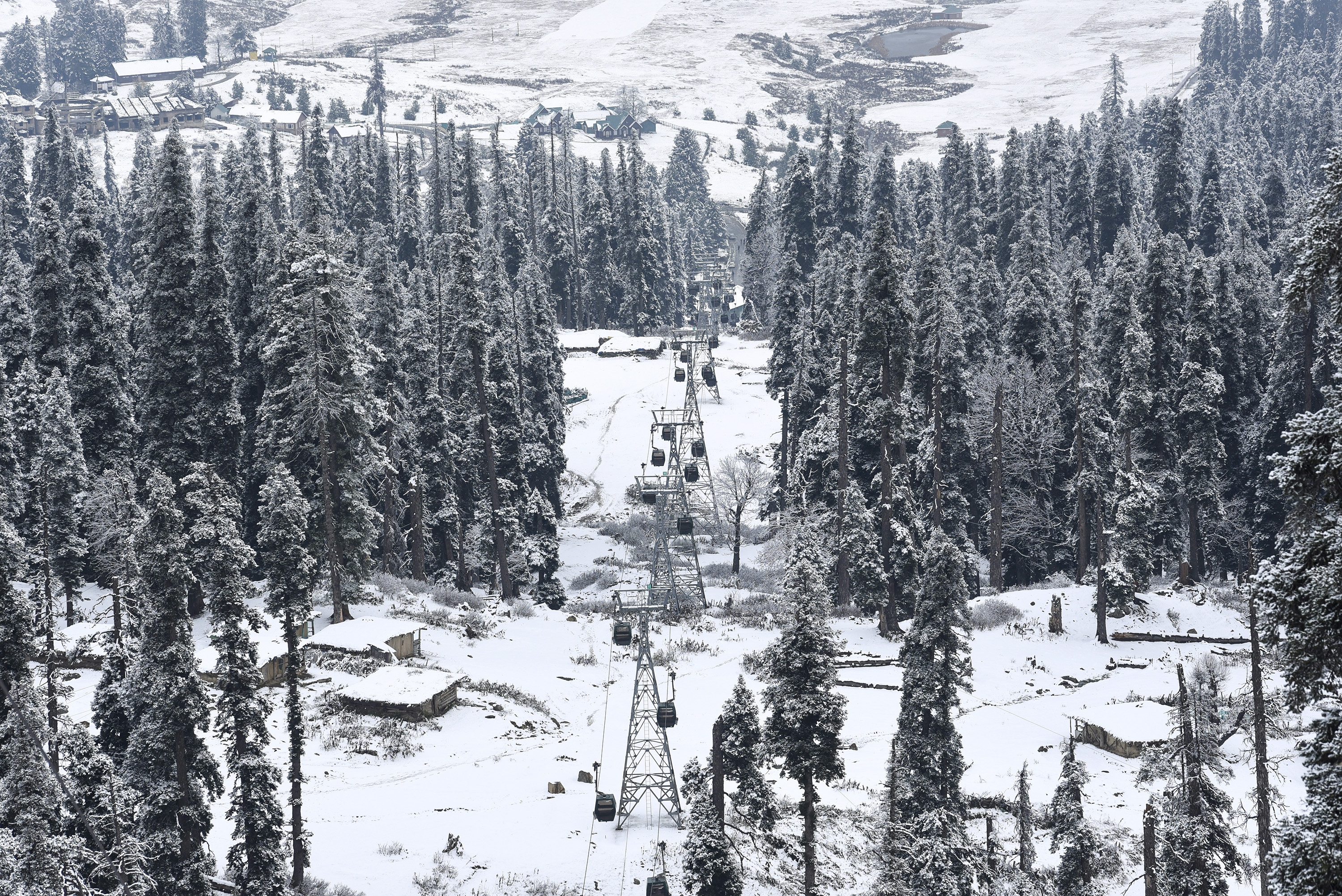 जम्मू-कश्मीर: बारामूला के गुलमर्ग में रोपवे के दोनों ओर देवदार के पेड़ बर्फ से ढक गए हैं।