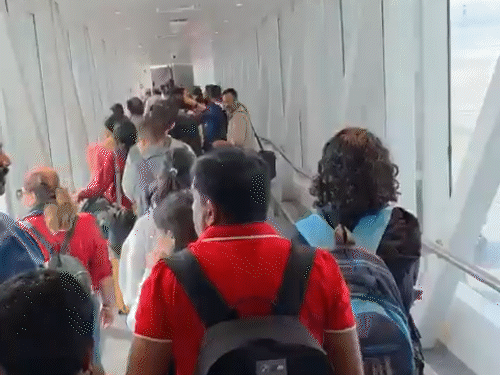 दिल्ली एयरपोर्ट के एयरोब्रिज पर यात्रियों की लंबी लाइन लगी रही।