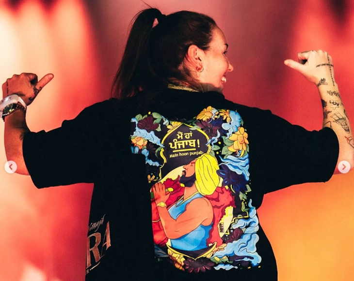 अमांडा वेलिंग्टन ने पीठ पर मैं हां पंजाब लिखी टी-शर्ट पहनी हुई थी।