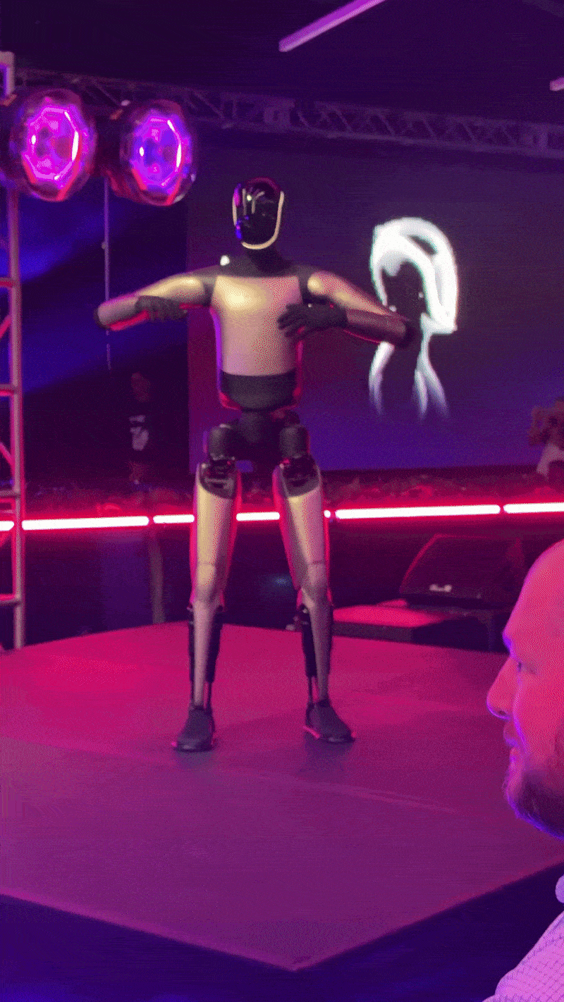 टेस्ला शेयरहोल्डर्स मीटिंग के फैसलों के बाद इलॉन मस्क और टेस्ला ऑप्टिमस ने डांस किया।