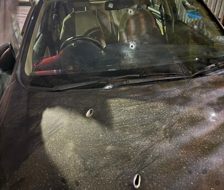 घर के बाहर खड़ी गाड़ी पर गोलियों के निशान।