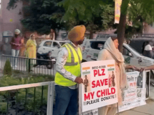 सड़क पर बच्चे के इलाज के लिए पैसे एकत्रित करते हुए फौजी परिवार।