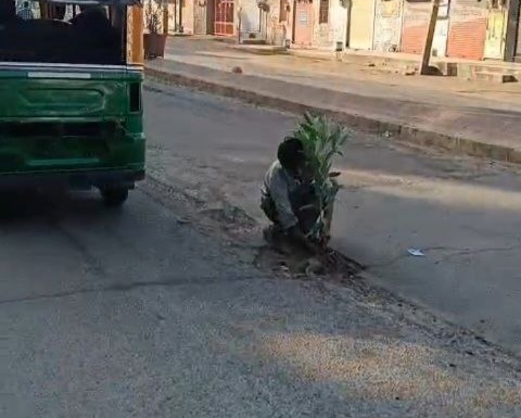 शहर के रेलवे स्टेशन रोड पर सड़क पर हो रखे गड्‌ढे में पौधा लगाते हुए।