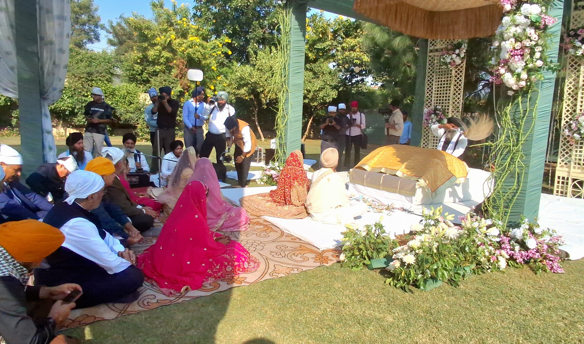 शादी में लावा-फेरे लेने से पहले बैठे दूल्हा-दुल्हन और बाराती।