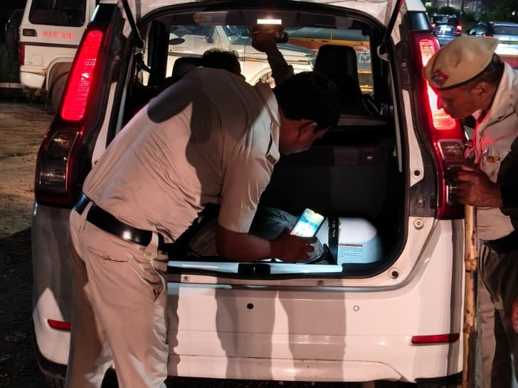 गाड़ी की तलाशी लेती पुलिस।