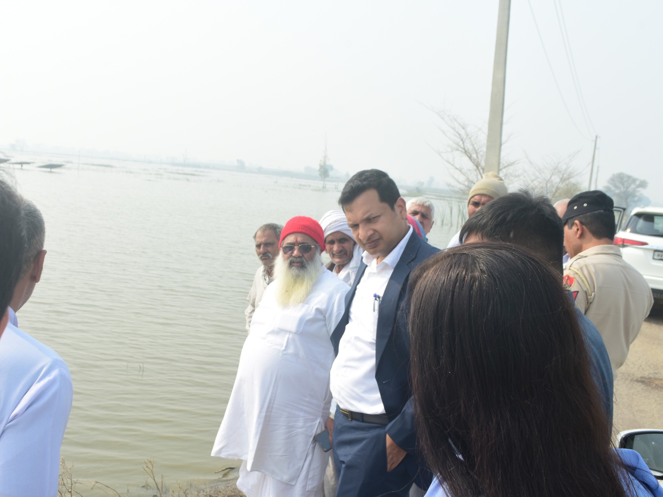 खेतों में भरे पानी को देखते अधिकारी।