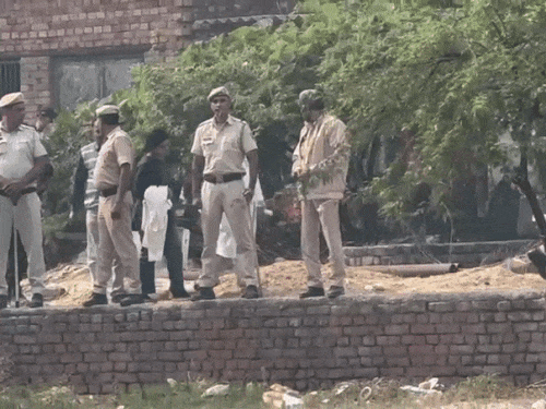 फरीदाबाद के खंदावली गांव में खड़ी लाल इको स्पोर्ट कार और जांच करने पहुंची दिल्ली की CFSL टीम।