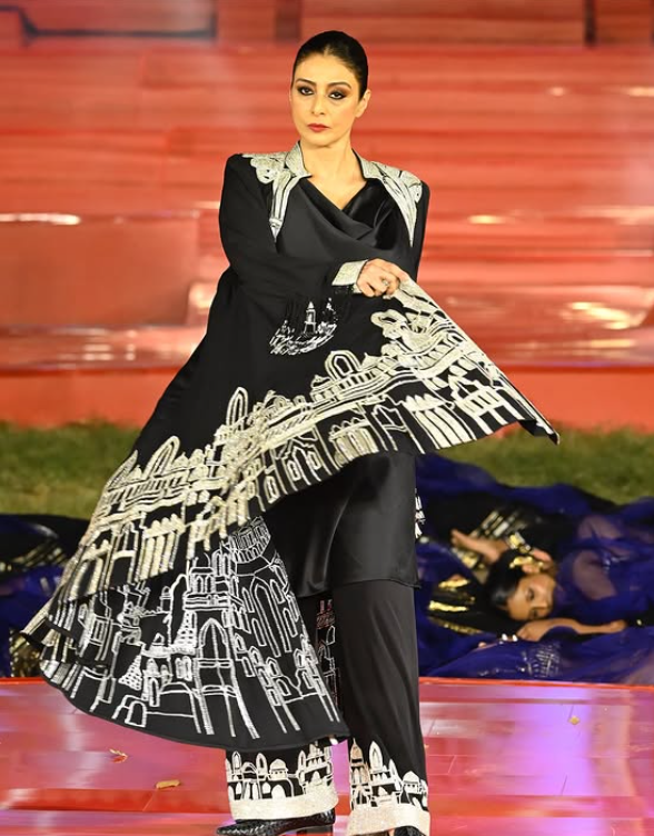 तबू ने ब्लैक ट्राउजर के साथ काउल नेक ट्यूनिक पहनी थी।