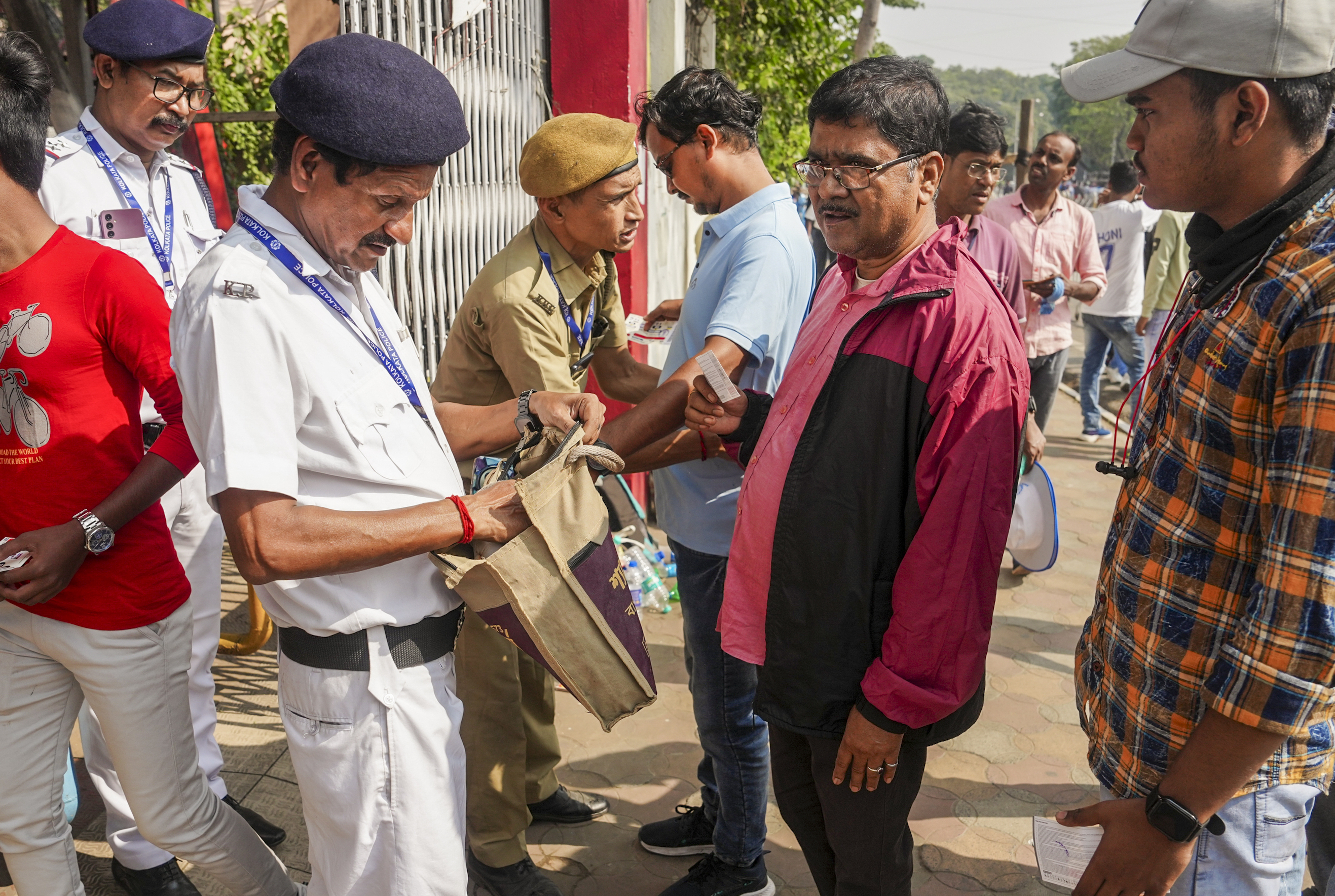 फैंस की चेकिंग करते सुरक्षा कर्मी।