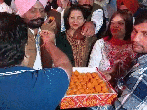 AAP की जीत पर लड्डू बांटते और डांस करते वर्कर।