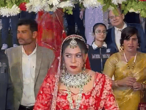 वर माला से पहले पूजा के भाई उसे स्टेज पर ले जाते हुए।