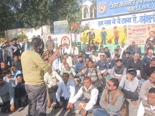 कलेक्ट्रेट के बाहर धरना देते बीएलओ और सुपरवाइजर।