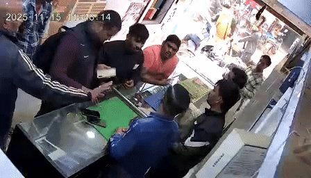 एकाएक दोनों हमलावर हो जाते हैं और दुकानदार की कॉलर पकड़कर हाथापाई करते हैं।