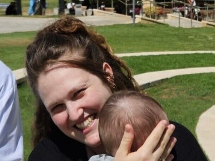 डॉ. हदास लेवी हॉस्पिटल के बाहर अपने बच्चे को गोद में लिए हुए।