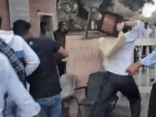 गुस्साए युवक गेट की कुर्सियों को तोड़ते हुए।